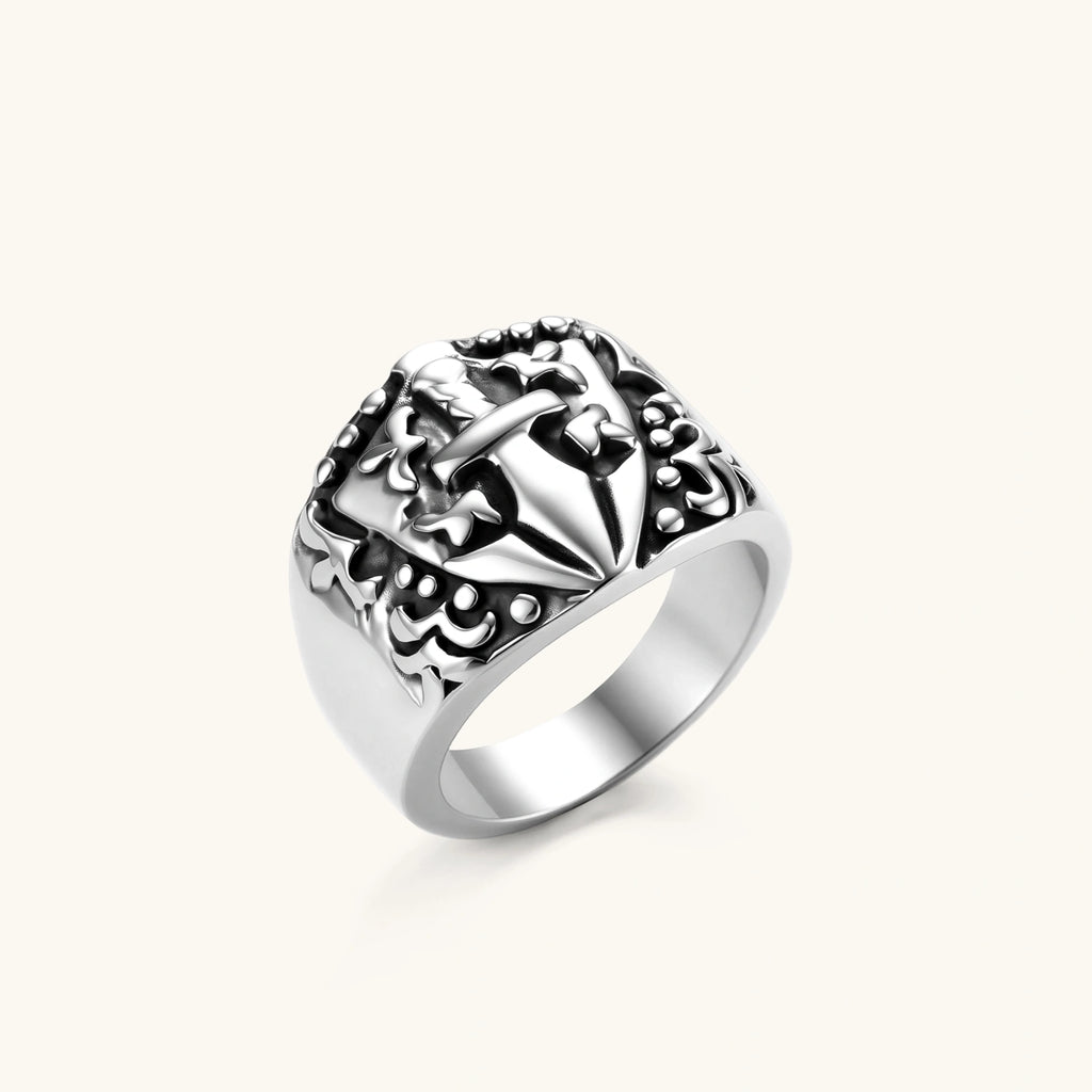 Silver 316L stainless steel men's signet ring with raised knight shield, cross motif, and ornate blackened scrollwork detailing.