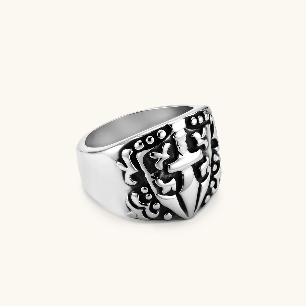 Silver 316L stainless steel men's signet ring with raised knight shield, cross motif, and ornate blackened scrollwork detailing.