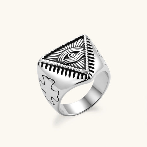 Silver stainless steel signet ring with engraved all-seeing eye in triangle, radiating lines, and cross motifs on the band.