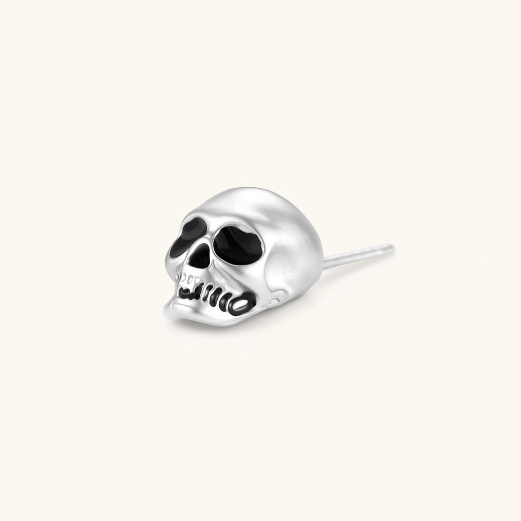 Matte silver skull stud earring with black enamel eye sockets and detailed teeth, post backing, 316L stainless steel.