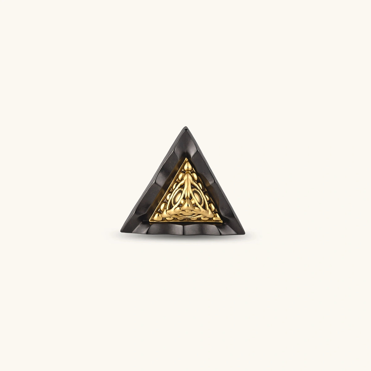 Single triangle stud earring with dark gunmetal outer frame and raised 18K gold-plated ornamental center, post back.