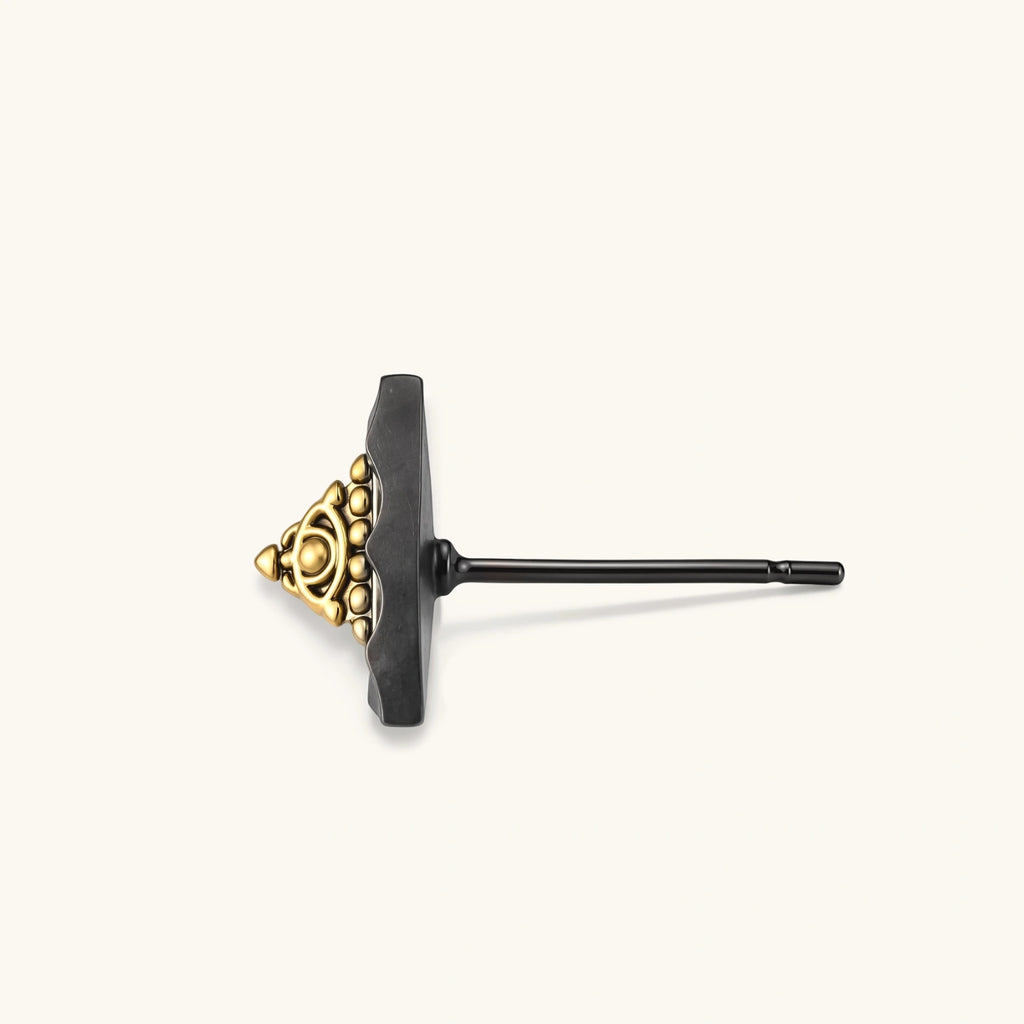 Single triangle stud earring with dark gunmetal outer frame and raised 18K gold-plated ornamental center, post back.