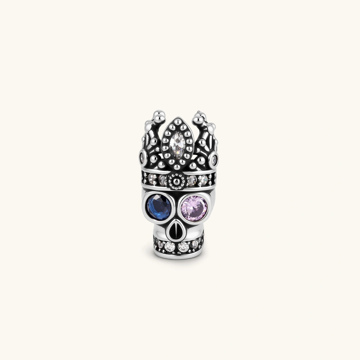 316L stainless steel skull stud earring with ornate crown top, blue and pink CZ eyes, and clear CZ accents on white background.
