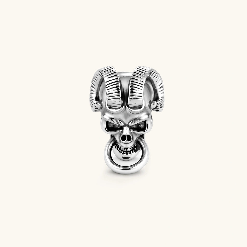 Silver 316L stainless steel stud earring shaped as a horned demon skull with ram horns and a dangling mouth ring.