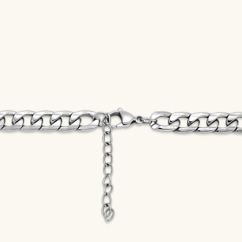 Silver 316L stainless steel carved curb chain necklace with lobster clasp and extender, 7.2mm wide, on cream background.