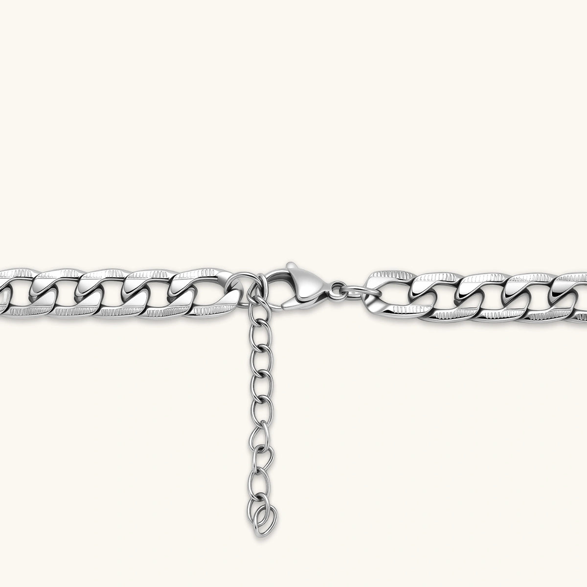 Silver 316L stainless steel carved curb chain necklace with lobster clasp and extender, 7.2mm wide, on cream background.