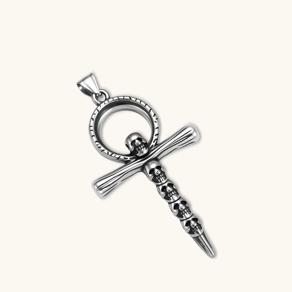 Silver stainless steel ankh pendant with skull motifs on vertical bar and textured ring top, on a box chain necklace.