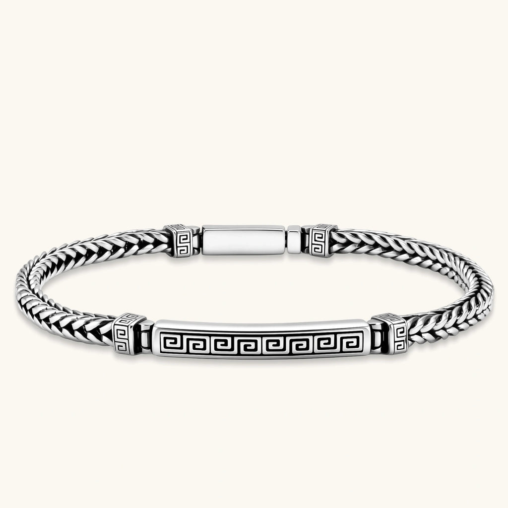 Silver stainless steel men's bracelet with braided foxtail chain, Greek key engraved bar, and decorative cube connectors.
