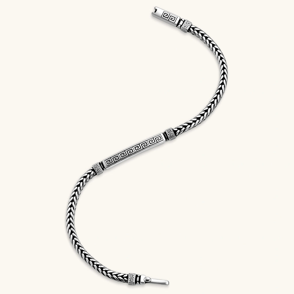 Silver stainless steel men's bracelet with braided foxtail chain, Greek key engraved bar, and decorative cube connectors.
