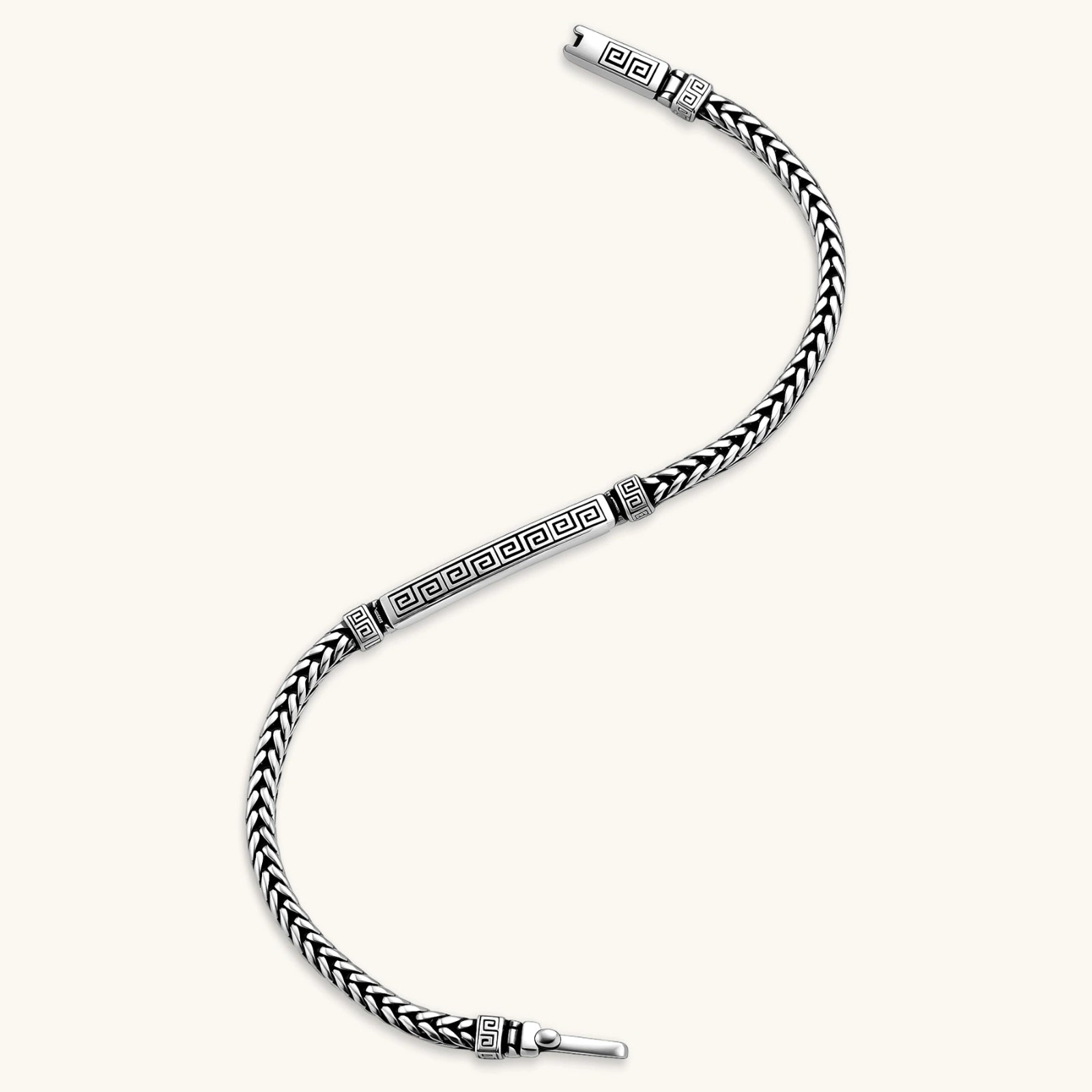 Silver stainless steel men's bracelet with braided foxtail chain, Greek key engraved bar, and decorative cube connectors.
