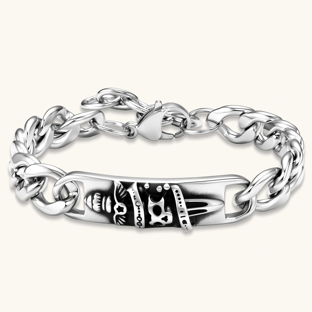Silver 316L stainless steel Cuban chain bracelet with blackened skull and crown ID bar centerpiece, lobster clasp closure.