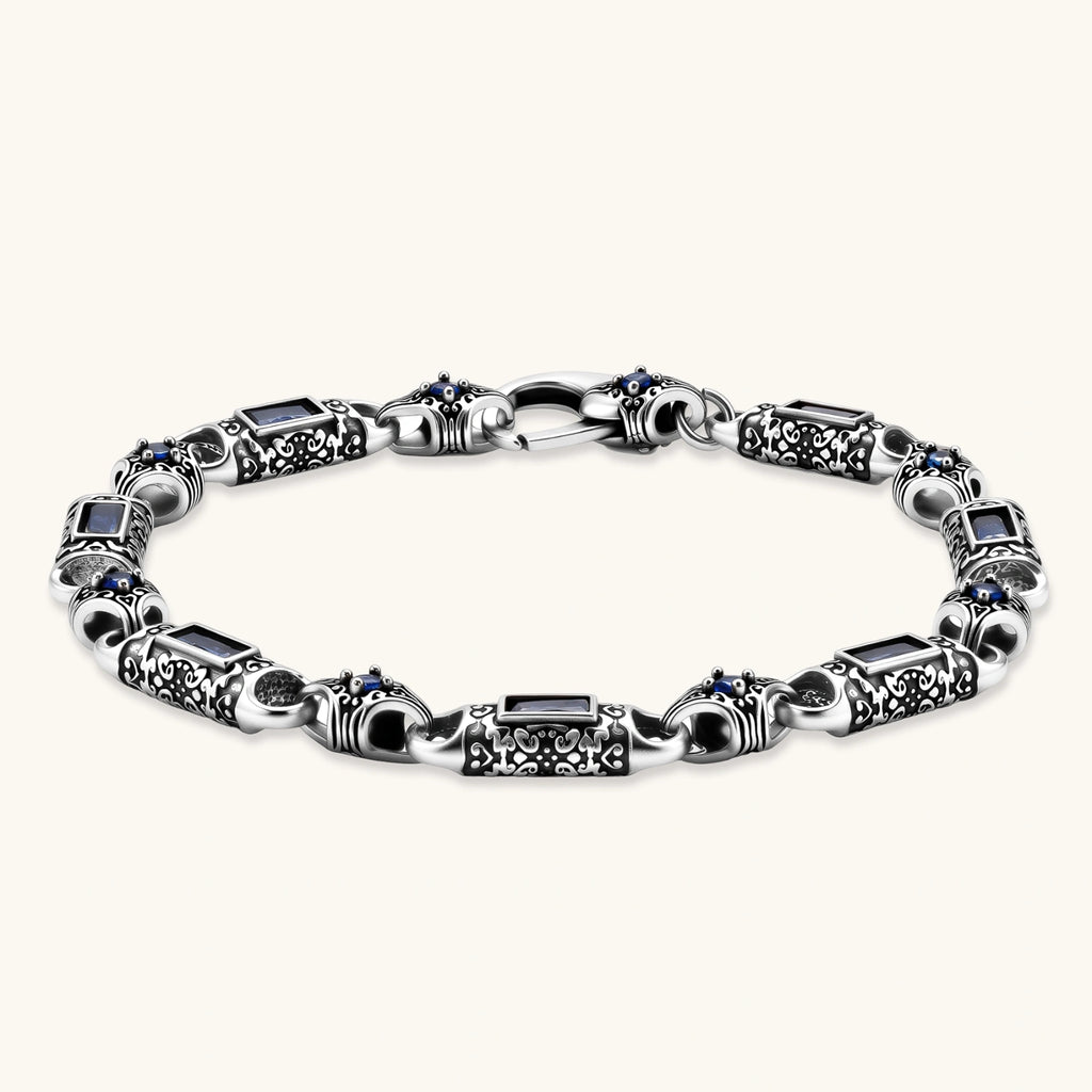 Oxidized silver stainless steel link bracelet with baguette blue CZ stones and intricate scroll engravings, lobster clasp.