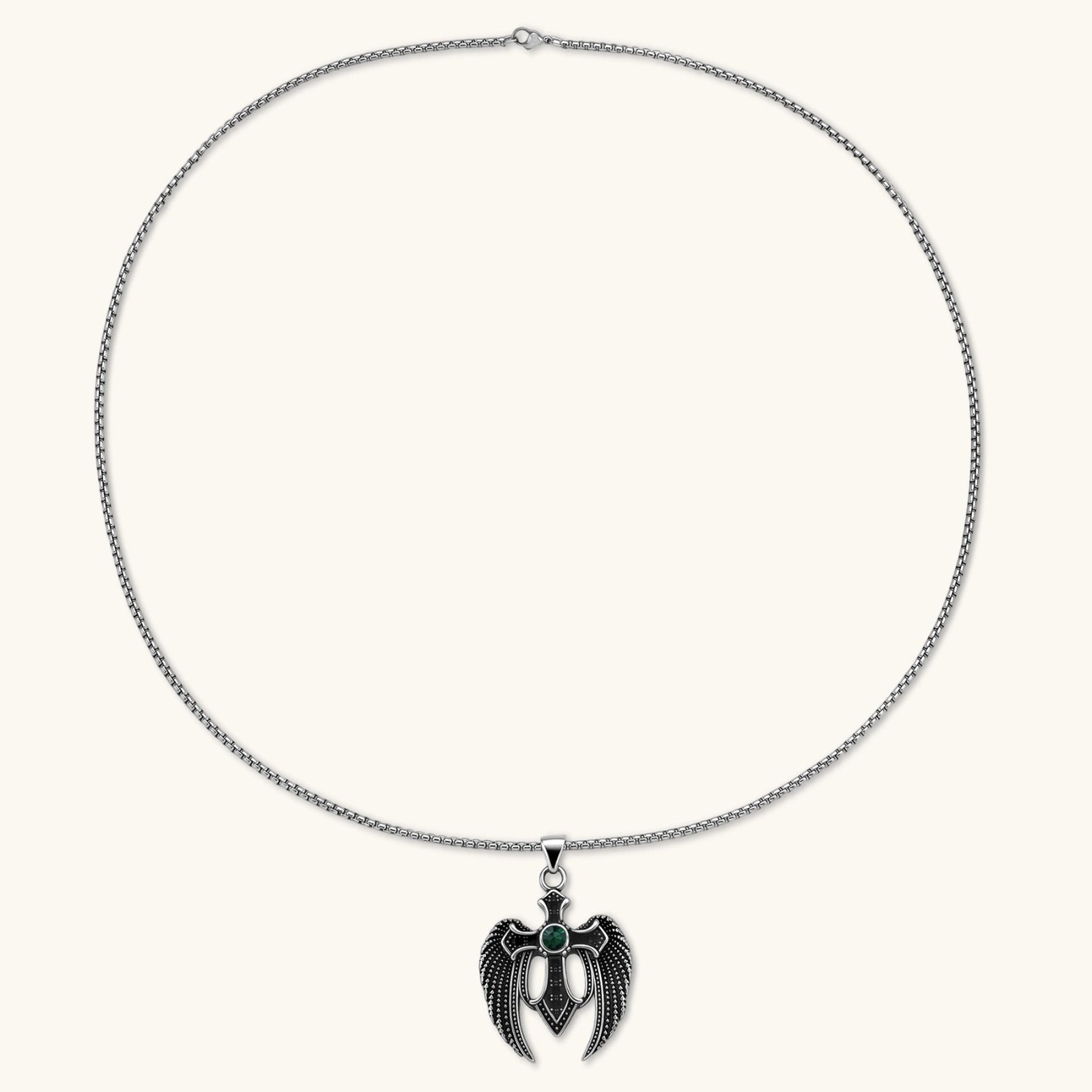 Silver stainless steel angel wing cross pendant necklace with green CZ center stone and black crystals on a box chain.