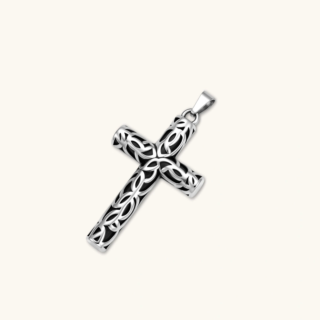 Silver stainless steel Celtic cross pendant with filigree vine pattern on a box chain, against a cream background.