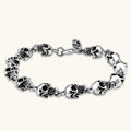 Silver stainless steel bracelet with linked 3D skull charms and a spring-ring clasp, oxidized black detailing, 225mm length.