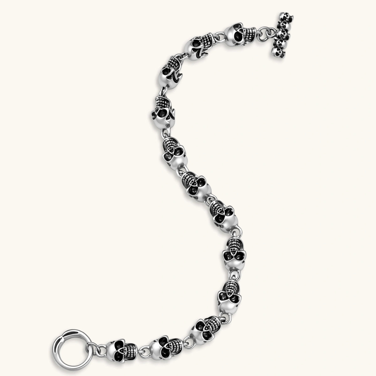 Silver stainless steel bracelet with linked 3D skull charms and a spring-ring clasp, oxidized black detailing, 225mm length.