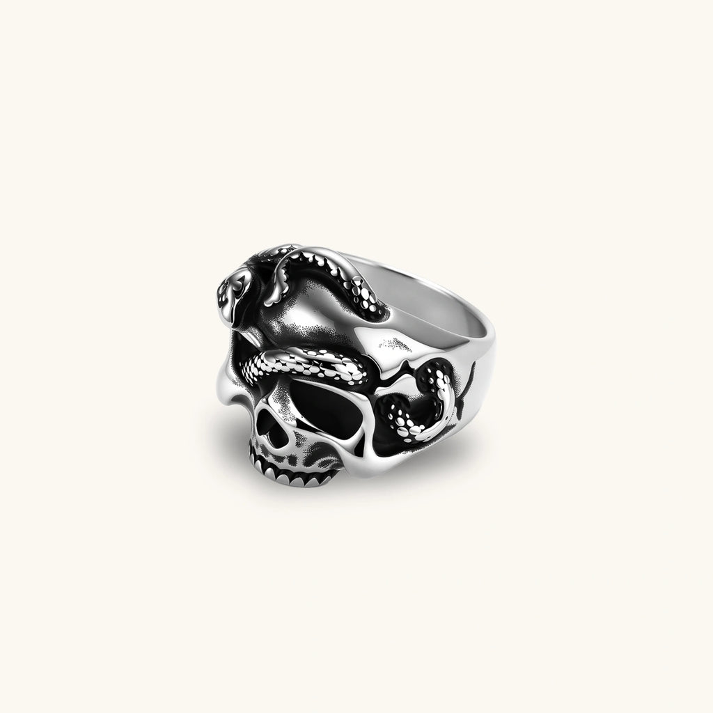 Silver stainless steel ring with bold skull face and coiled snake wrapping the crown, blackened recessed details.