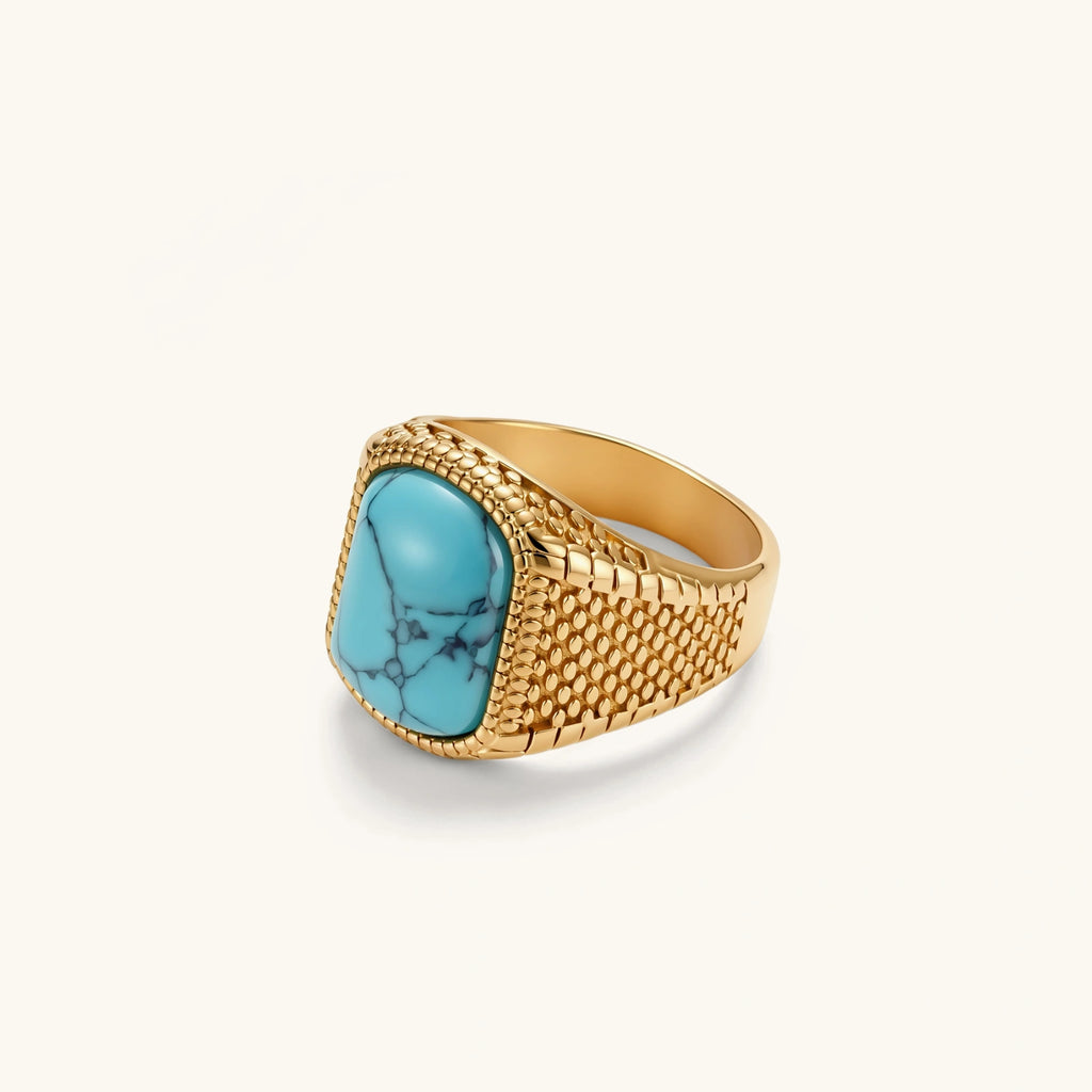 Gold PVD stainless steel signet ring with cushion faux turquoise stone and textured honeycomb band, front view.