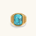 Gold PVD stainless steel signet ring with cushion faux turquoise stone and textured honeycomb band, front view.