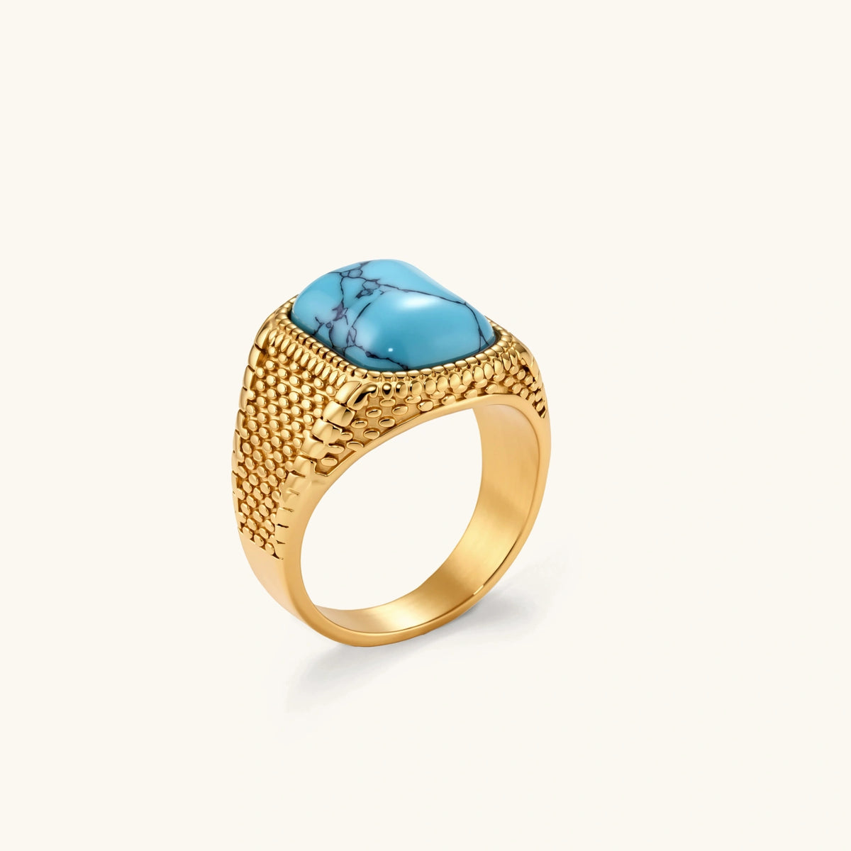 Gold PVD stainless steel signet ring with cushion faux turquoise stone and textured honeycomb band, front view.